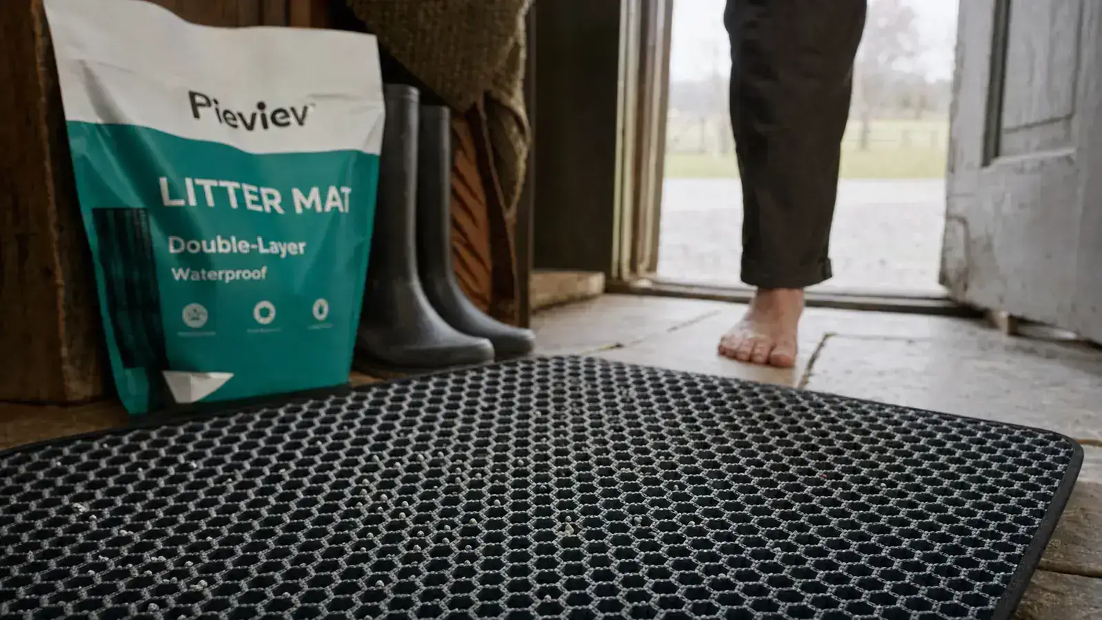 Close-up of a double-layer honeycomb litter mat showing loose litter granules caught in the top layer's holes